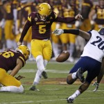 Arizona State's Zane Gonzalez (5) kicks a field goal from the hold of Matt Haack (26) as Northern Arizona's Maurice Davison (20) arrives late during the first half of an NCAA college football game Saturday, Sept. 3, 2016, in Tempe, Ariz. (AP Photo/Ross D. Franklin)