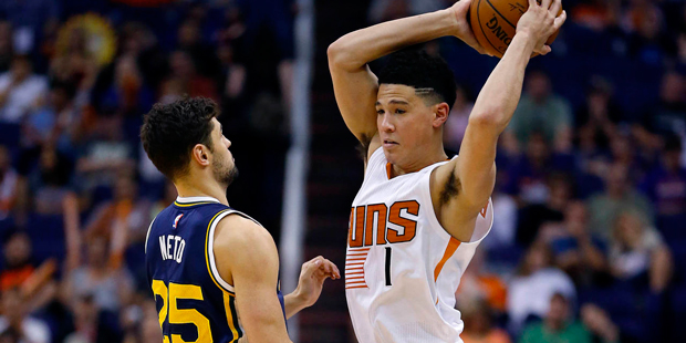 Phoenix Suns guard Devin Booker (1) looks to pass under pressure from Utah Jazz guard Raul Neto (25...