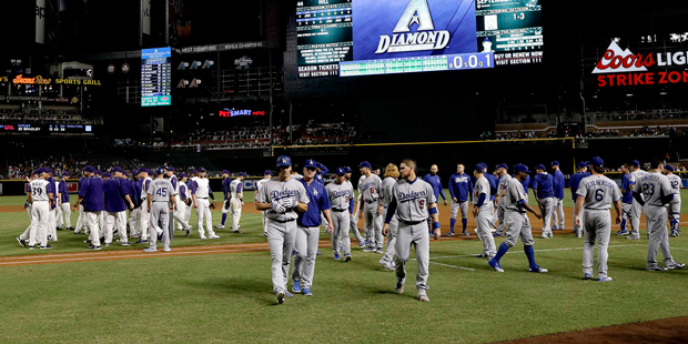 The Los Angeles Dodgers and the Arizona Diamondbacks benches walk back to their dugouts after words...