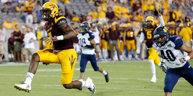 Arizona State's Kalen Ballage, left, jumps into the end zone for a touchdown as he gets past Northe...