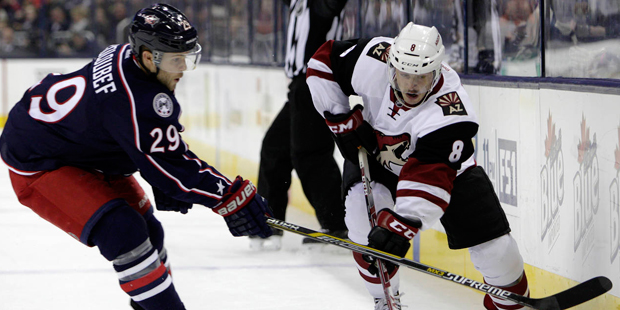 Columbus Blue Jackets' Cody Goloubef, left, tries to steal the puck from Arizona Coyotes' Tobias Ri...