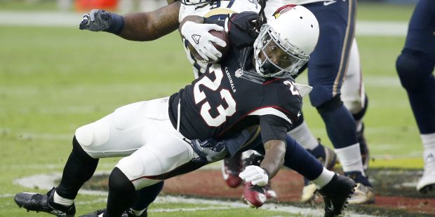 Arizona Cardinals running back Chris Johnson (23) is tackled by Los Angeles Rams defensive end Euge...