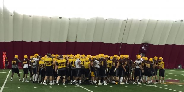 ASU football players, including Tyler McClure (75) huddle during practice. (Ryan Decker / Cronkite ...