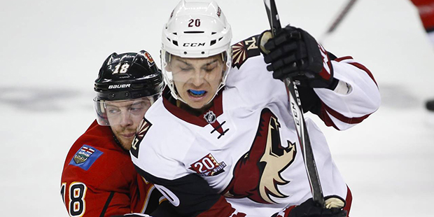 Arizona Coyotes' Dylan Strome, right, tries to get past Calgary Flames' Matt Stajan during the seco...