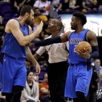 Dallas Mavericks center Andrew Bogut, left, is held back by referee Leon Wood and teammate Wesley Matthews after a hard foul by Phoenix Suns forward Marquese Chriss during the first half of an NBA preseason basketball game, Friday, Oct. 14, 2016, in Phoenix. Both Bogut and Chriss were given technical fouls. (AP Photo/Matt York)