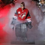 Arizona Coyotes goalie Mike Smith emerges from the smoke during player introductions prior to an NHL hockey game against the Philadelphia Flyers on Saturday, Oct. 15, 2016, in Glendale, Ariz. The Coyotes defeated the Flyers 4-3 in overtime. (AP Photo/Ross D. Franklin)