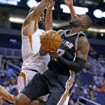 San Antonio Spurs' Jonathon Simmons, right, goes up for a shot against Phoenix Suns' Tyson Chandler, left, during the first half of an NBA preseason basketball game Monday, Oct. 3, 2016, in Phoenix. (AP Photo/Ross D. Franklin)
