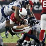 Arizona Cardinals quarterback Carson Palmer (3) is sacked by Seattle Seahawks defensive end Frank Clark (55), defensive end Michael Bennett (72) and defensive end Cliff Avril, left, during the first half of a football game, Sunday, Oct. 23, 2016, in Glendale, Ariz. (AP Photo/Ross D. Franklin)