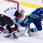 Vancouver Canucks' Tuomo Ruutu, right, of Finland, is checked into Arizona Coyotes' goalie Louis Domingue, back, by Luke Schenn during the second period of a preseason NHL hockey game in Vancouver, British Columbia, Monday, Oct. 3, 2016. (Darryl Dyck/The Canadian Press via AP)