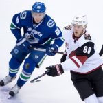 Arizona Coyotes' Jamie McGinn, right, and Vancouver Canucks' Markus Granlund, of Finland, watch the puck during the first period of a preseason NHL hockey game against the Arizona Coyotes in Vancouver, British Columbia, Monday, Oct. 3, 2016. (Darryl Dyck/The Canadian Press via AP)