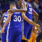 Golden State Warriors guard Stephen Curry (30) and Kevin Durant (35) hug during the second half of an NBA basketball game against the Phoenix Suns Sunday, Oct. 30, 2016, in Phoenix. The Warriors defeated the Suns 106-100. (AP Photo/Ross D. Franklin)