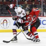 Arizona Coyotes left wing Anthony Duclair (10) and New Jersey Devils defenseman Ben Lovejoy (12) vie for the puck during the first period of an NHL hockey game, Tuesday, Oct. 25, 2016, in Newark, N.J. (AP Photo/Julie Jacobson)