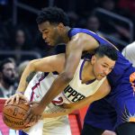 Phoenix Suns forward T.J. Warren, right, reach over Los Angeles Clippers guard Austin Rivers for the ball during the first half of an NBA basketball game, Monday, Oct. 31, 2016, in Los Angeles. (AP Photo/Mark J. Terrill)