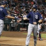 San Diego Padres' Austin Hedges, right, is congratulated by teammate Adam Rosales (9) after scoring a run against the Arizona Diamondbacks during the seventh inning of a baseball game, Sunday, Oct. 2, 2016, in Phoenix. (AP Photo/Ralph Freso)