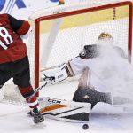 Anaheim Ducks goalie Jonathan Bernier, right, makes a save on a shot by Arizona Coyotes' Christian Dvorak (18) as the goalie gets snowed by a teammate during overtime of a preseason NHL hockey game Saturday, Oct. 1, 2016, in Glendale, Ariz.  The Coyotes defeated the Ducks 3-2 in overtime. (AP Photo/Ross D. Franklin)