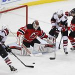 New Jersey Devils goalie Cory Schneider (35) blocks a shot by Arizona Coyotes left wing Jordan Martinook (48) as Arizona Coyotes left wing Anthony Duclair (10) looks for the rebound during the third period of an NHL hockey game, Tuesday, Oct. 25, 2016, in Newark, N.J. (AP Photo/Julie Jacobson)