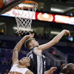 San Antonio Spurs' Davis Bertans, middle, blocks the shot of Phoenix Suns' Devin Booker (1) as Spurs' Joel Anthony, right, watches during the second half of an NBA preseason basketball game Monday, Oct. 3, 2016, in Phoenix. The Suns won 91-86. (AP Photo/Ross D. Franklin)