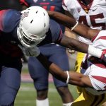 Arizona running back Nick Wilson, left, stiff-arms Southern California defensive back Marvell Tell III (7) during the first half of an NCAA college football game, Saturday, Oct. 15, 2016, in Tucson, Ariz. (AP Photo/Rick Scuteri)