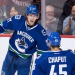 Vancouver Canucks' Ben Hutton, back, and Michael Chaput celebrate Hutton's goal against the Arizona Coyotes during the second period of a preseason NHL hockey game in Vancouver, British Columbia, Monday, Oct. 3, 2016. (Darryl Dyck/The Canadian Press via AP)