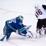 Vancouver Canucks' goalie Jacob Markstrom, left, of Sweden, comes out of his crease to poke-check the puck away from Arizona Coyotes' Max Domi on a breakaway during the second period of a preseason NHL hockey game in Vancouver, British Columbia, Monday, Oct. 3, 2016. (Darryl Dyck/The Canadian Press via AP)