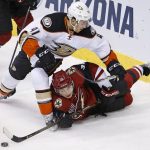 Arizona Coyotes' Nick Merkley (38) tries to get off a shot as he is sent to the ice by Anaheim Ducks' Corey Tropp (41) during the third period of a preseason NHL hockey game Saturday, Oct. 1, 2016, in Glendale, Ariz.  The Coyotes defeated the Ducks 3-2 in overtime. (AP Photo/Ross D. Franklin)