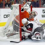 Arizona Coyotes' Brad Richardson (15) collides with Philadelphia Flyers goalie Steve Mason after scoring a goal during the third period of an NHL hockey game, Thursday, Oct. 27, 2016, in Philadelphia. The goal was reviewed and challenged but the call stood. (AP Photo/Tom Mihalek)