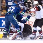 Vancouver Canucks' Tuomo Ruutu, back center, of Finland, falls over Arizona Coyotes' goalie Louis Domingue as he covers up the puck while teammate Brad Richardson, right, and Canucks' Joseph Labate watch during the first period of a preseason NHL hockey game in Vancouver, British Columbia, Monday Oct. 3, 2016. (Darryl Dyck/The Canadian Press via AP)