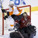 Arizona Coyotes' Mike Smith, right, makes a save on a shot as Philadelphia Flyers' Jakub Voracek (93) jumps in the air during the third period of an NHL hockey game Saturday, Oct. 15, 2016, in Glendale, Ariz. The Coyotes defeated the Flyers 4-3. (AP Photo/Ross D. Franklin)