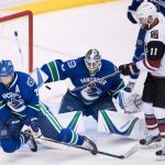 Vancouver Canucks' Alexander Edler, left, of Sweden, deflects the puck wide of the net in front of goalie Jacob Markstrom, of Sweden, as Arizona Coyotes' Martin Hanzal, right, of the Czech Republic, watches during the second period of a preseason NHL hockey game in Vancouver, British Columbia, Monday, Oct. 3, 2016. (Darryl Dyck/The Canadian Press via AP)