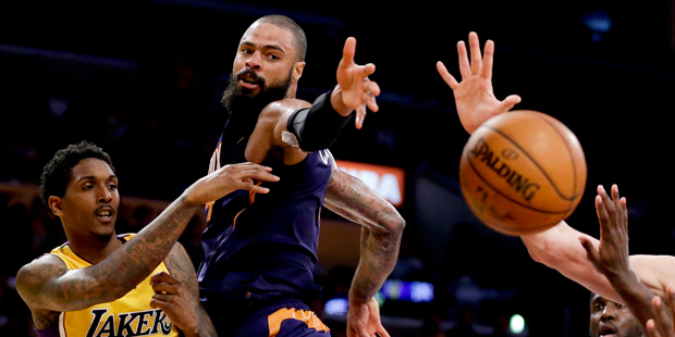 Los Angeles Lakers guard Lou Williams, left, passes around Phoenix Suns center Tyson Chandler durin...