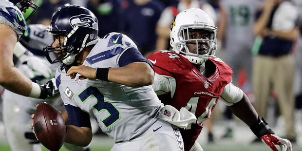 Seattle Seahawks quarterback Russell Wilson (3) scrambles away from the reach of Arizona Cardinals ...