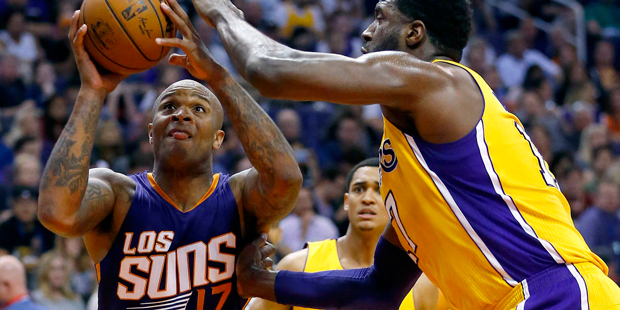 Phoenix Suns forward P.J. Tucker (17) drives as Los Angeles Lakers center Roy Hibbert, right, defen...