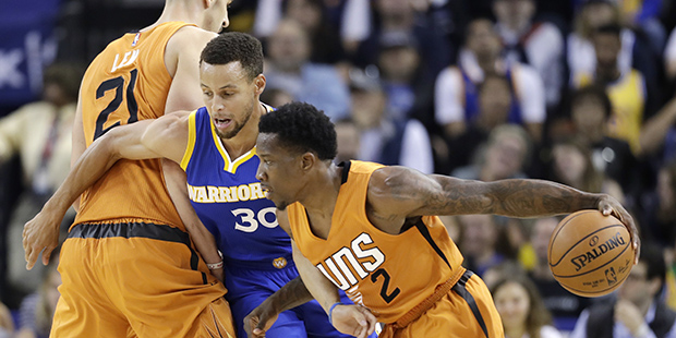 Phoenix Suns' Eric Bledsoe (2) dribbles around Golden State Warriors' Stephen Curry (30) on a scree...