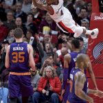 Portland Trail Blazers forward Maurice Harkless hands from the rim after a dunk against Phoenix Suns forward Dragan Bender during the second half of an NBA basketball game in Portland, Ore., Tuesday, Nov. 8, 2016. (AP Photo/Craig Mitchelldyer)