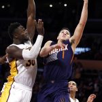 Phoenix Suns guard Devin Booker (1) shoots against Los Angeles Lakers forward Julius Randle (30) with guard Jordan Clarkson (6) watching during the second half of an NBA basketball game in Los Angeles, Sunday, Nov. 6, 2016. The Lakers won 119-108. (AP Photo/Alex Gallardo)