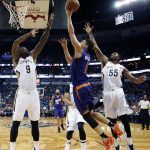 Phoenix Suns guard Devin Booker (1) goes to the basket between New Orleans Pelicans forward Terrence Jones (9) and guard E'Twaun Moore (55) during the first half of an NBA basketball game in New Orleans, Friday, Nov. 4, 2016. (AP Photo/Gerald Herbert)