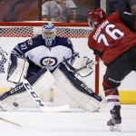 Arizona Coyotes center Laurent Dauphin (76) sends the puck at Winnipeg Jets goalie Connor Hellebuyck (37) during the first period of an NHL hockey game Thursday, Nov. 10, 2016, in Glendale, Ariz. (AP Photo/Ross D. Franklin)