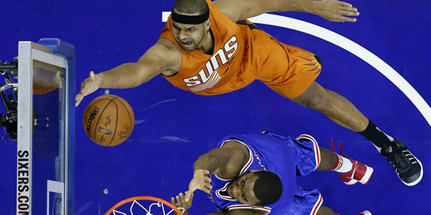 Phoenix Suns' Jared Dudley, top, tries to get a shot past Philadelphia 76ers' Hollis Thompson durin...