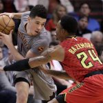 Phoenix Suns guard Devin Booker is defended by Atlanta Hawks forward Kent Bazemore (24) during the first half of an NBA basketball game, Wednesday, Nov. 30, 2016, in Phoenix. (AP Photo/Matt York)