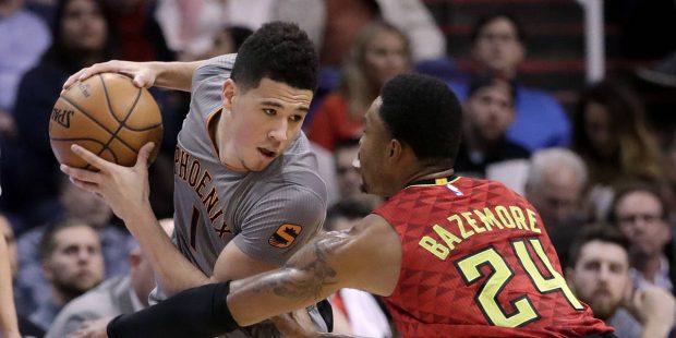 Phoenix Suns guard Devin Booker is defended by Atlanta Hawks forward Kent Bazemore (24) during the ...