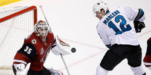 Arizona Coyotes goalie Louis Domingue (35) makes a save on a deflection by San Jose Sharks left win...