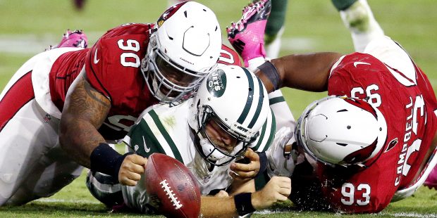 New York Jets quarterback Ryan Fitzpatrick (14) is hit by Arizona Cardinals defensive tackle Robert...