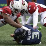 Seattle Seahawks quarterback Russell Wilson (3) is sacked by Arizona Cardinals outside linebacker Markus Golden (44) defensive end Calais Campbell, left, in the first half of an NFL football game, Saturday, Dec. 24, 2016, in Seattle. (AP Photo/Ted S. Warren)