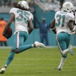 Miami Dolphins free safety Walt Aikens (35) runs for two points after the Miami Dolphins blocked an extra point attempt by the Arizona Cardinals during the second half of an NFL football game, Sunday, Dec. 11, 2016, in Miami Gardens, Fla. To the right is Miami Dolphins free safety Michael Thomas (31). (AP Photo/Lynne Sladky)
