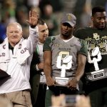 Baylor head coach Jim Grobe holds the champions trophy, wide receiver KD Cannon (9) holds the offensive player of the game award, and defensive end Tyrone Hunt (90) holds the defensive player of the game award after the Cactus Bowl NCAA college football game against Boise State, Wednesday, Dec. 28, 2016, in Phoenix. Baylor won 31-12. (AP Photo/Rick Scuteri)