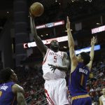 Houston Rockets forward Montrezl Harrell (5) shoots a over Phoenix Suns guard Devin Booker (1) as guard Eric Bledsoe, left, looks on in the first half of an NBA basketball game on Monday, Dec. 26, 2016 in Houston. (AP Photo/Bob Levey)