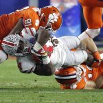 Ohio State running back Curtis Samuel, center, is tackled by Clemson defensive end Austin Bryant (91) and Tanner Muse during the first half of the Fiesta Bowl NCAA college football playoff semifinal, Saturday, Dec. 31, 2016, in Glendale, Ariz. (AP Photo/Ross D. Franklin)