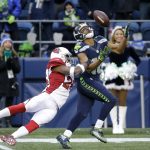 Seattle Seahawks' Tyler Lockett, right, catches the ball as Arizona Cardinals' Brandon Williams moves in for the tackle in the first half of an NFL football game, Saturday, Dec. 24, 2016, in Seattle. (AP Photo/Ted S. Warren)