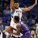 Minnesota Timberwolves' Karl-Anthony Towns, top, looms over Phoenix Suns' Eric Bledsoe during the second half of an NBA basketball game Monday, Dec. 19, 2016, in Minneapolis. The Timberwolves won 115-108. (AP Photo/Jim Mone)