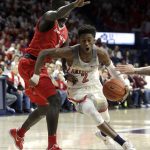 Arizona guard Kobi Simmons (2) drives on New Mexico center Obij Aget during the second half of an NCAA college basketball game, Tuesday, Dec. 20, 2016, in Tucson, Ariz. (AP Photo/Rick Scuteri)